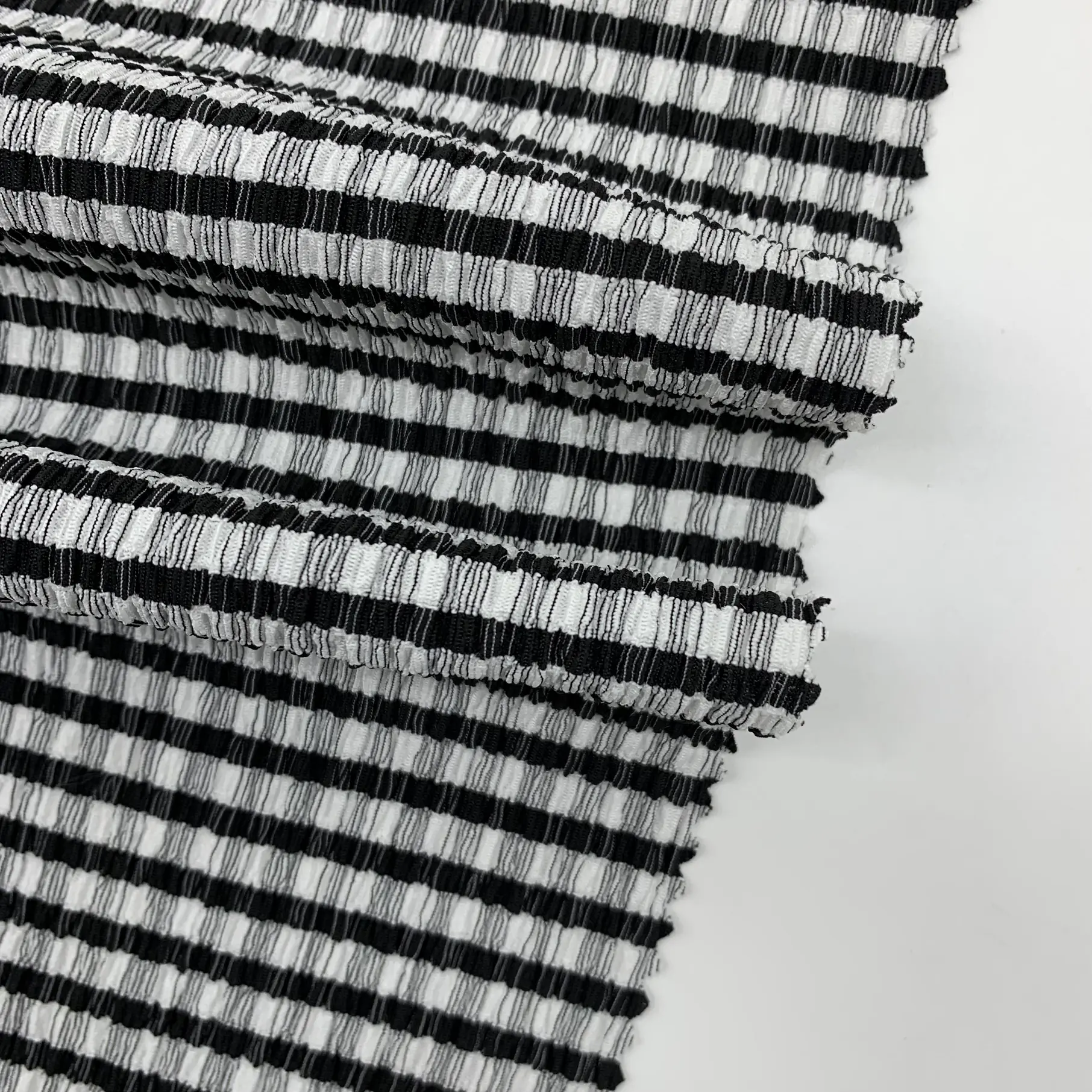 Close up of black white checkered crepe knit fabric showing woven pattern and texture